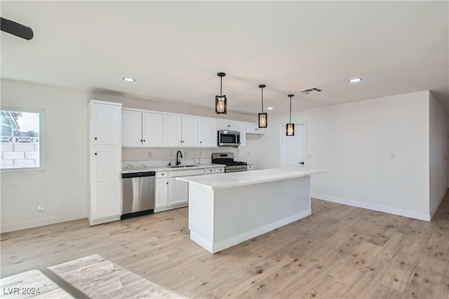 kitchen with white cabinets, decorative light fixtures, stainless steel appliances, and sink