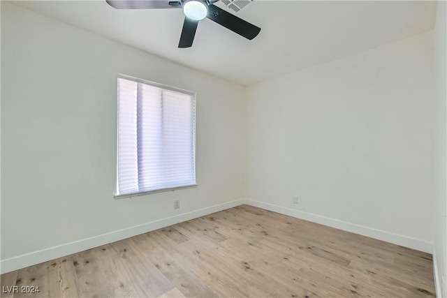 empty room with ceiling fan and light hardwood / wood-style flooring