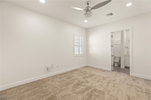 unfurnished bedroom with ensuite bathroom, ceiling fan, and light colored carpet