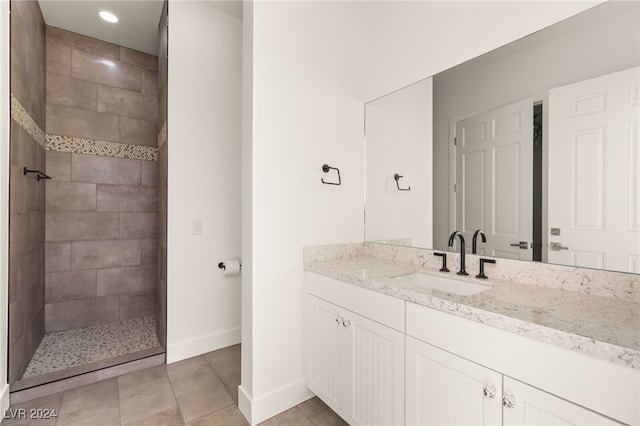 bathroom featuring tile patterned flooring, vanity, and tiled shower