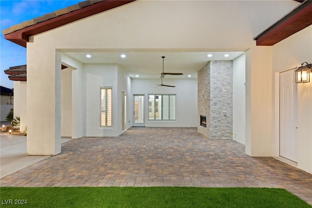 exterior space with a stone fireplace and ceiling fan