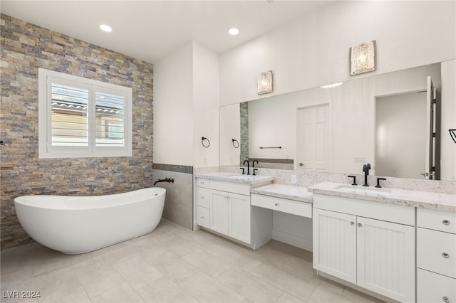 bathroom featuring vanity, tile patterned floors, tile walls, and a bathing tub