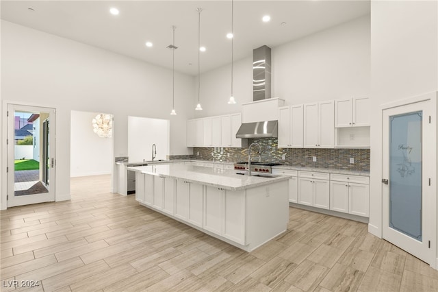 kitchen featuring hanging light fixtures, a high ceiling, and ventilation hood