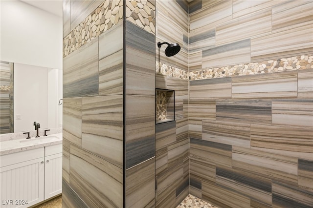 bathroom with vanity and a tile shower