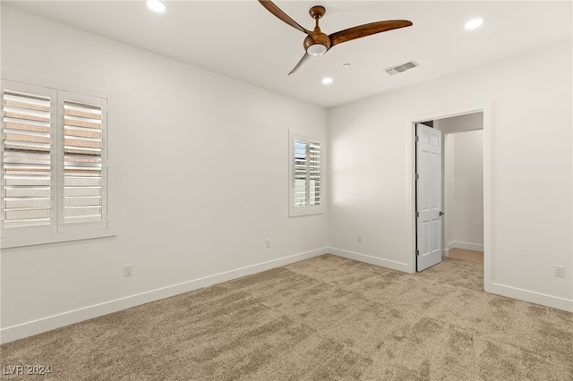 unfurnished bedroom with ceiling fan, light carpet, and multiple windows