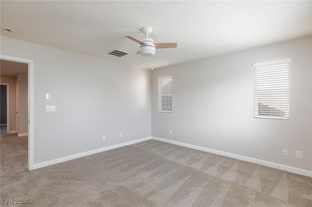 empty room featuring ceiling fan and light colored carpet