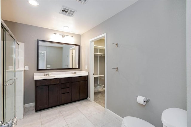 bathroom with tile patterned floors, vanity, toilet, and an enclosed shower