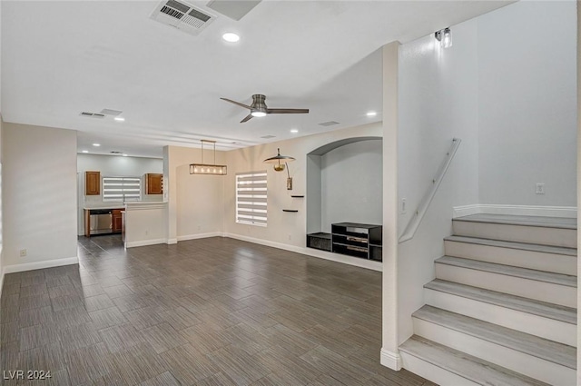 unfurnished living room featuring ceiling fan and dark hardwood / wood-style flooring