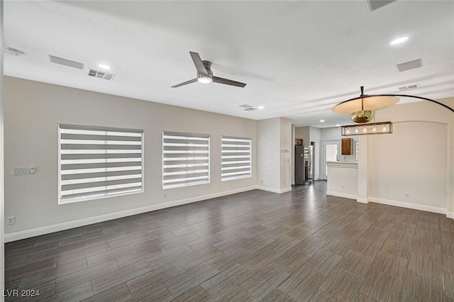 unfurnished living room with ceiling fan and dark hardwood / wood-style flooring