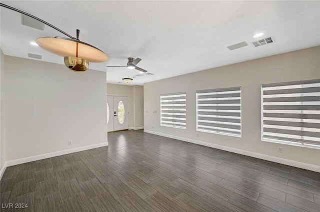 unfurnished living room with dark hardwood / wood-style floors and ceiling fan