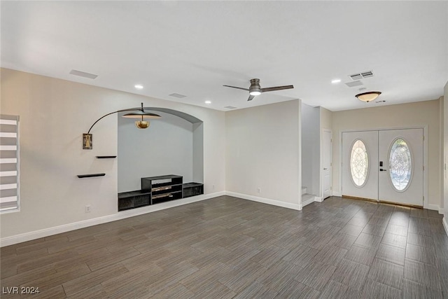 unfurnished living room featuring french doors, ceiling fan, and dark wood-type flooring