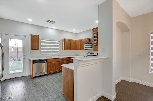 kitchen with kitchen peninsula, sink, and appliances with stainless steel finishes