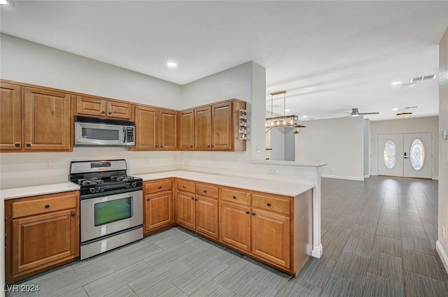 kitchen with kitchen peninsula, french doors, stainless steel appliances, and ceiling fan