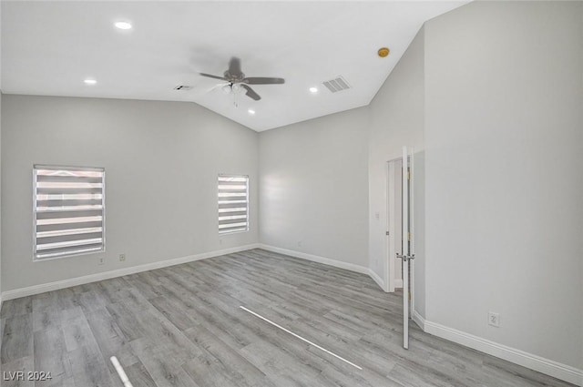 spare room with ceiling fan, lofted ceiling, and light hardwood / wood-style flooring