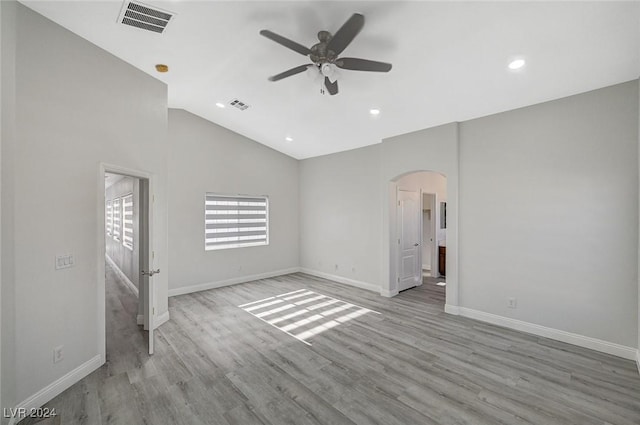 spare room with light hardwood / wood-style flooring, vaulted ceiling, and ceiling fan