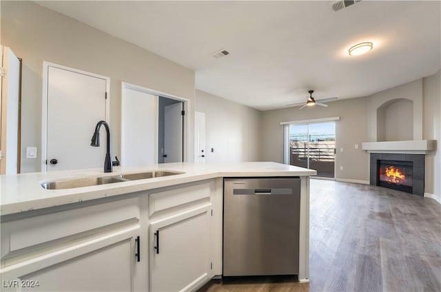 kitchen with dishwasher, sink, a fireplace, light hardwood / wood-style floors, and white cabinetry