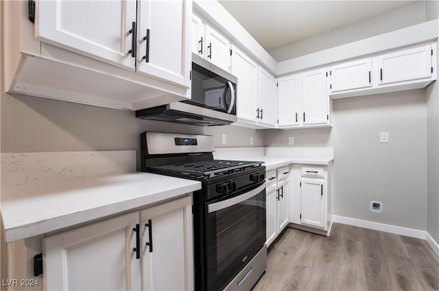 kitchen with white cabinetry, stainless steel appliances, and light hardwood / wood-style floors