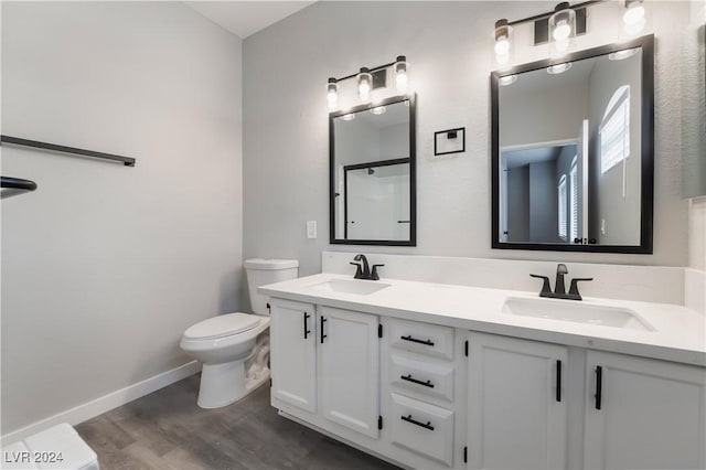 bathroom with vanity, wood-type flooring, and toilet