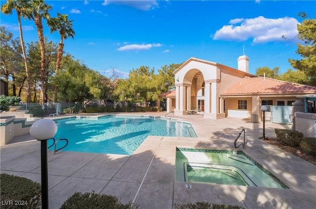 view of pool with a patio area, cooling unit, and a hot tub