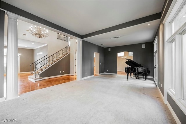 living room with wood-type flooring, decorative columns, and a notable chandelier