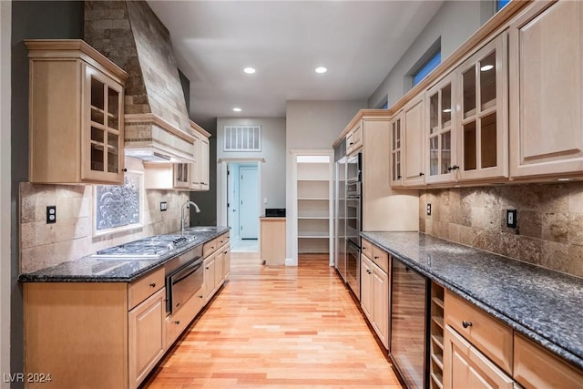 kitchen with premium range hood, light brown cabinets, light hardwood / wood-style flooring, wine cooler, and stainless steel gas stovetop