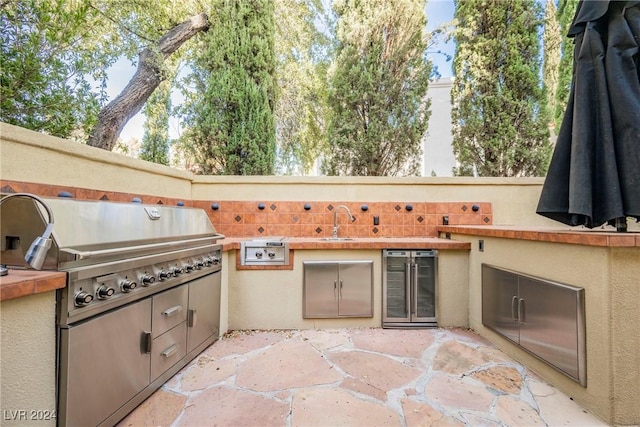 view of patio / terrace with area for grilling, a grill, sink, and beverage cooler