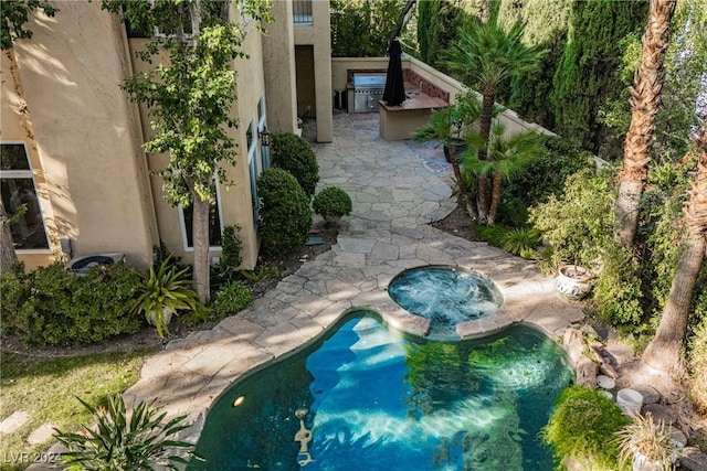 view of pool with an in ground hot tub and a patio