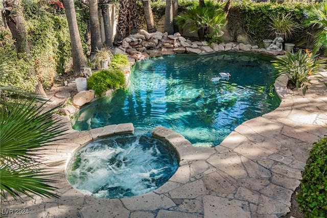 view of swimming pool featuring an in ground hot tub