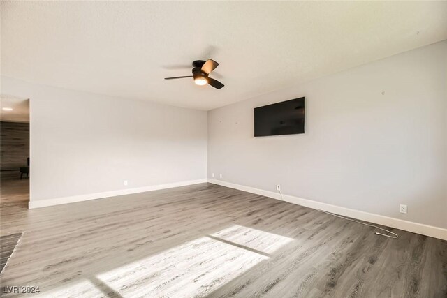 empty room with hardwood / wood-style flooring and ceiling fan