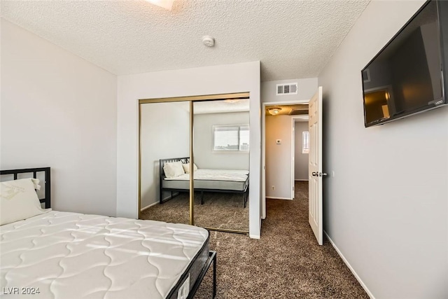 carpeted bedroom with a textured ceiling and a closet