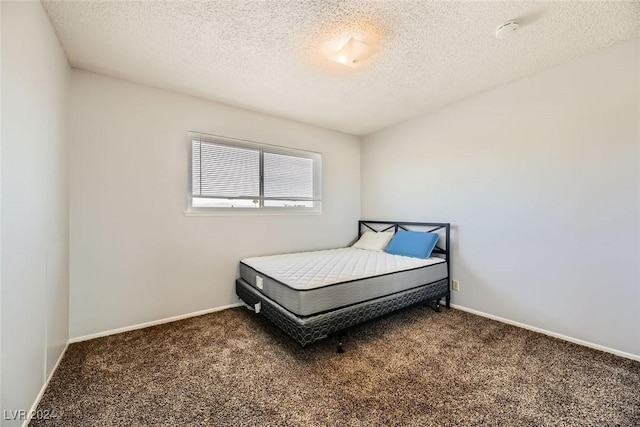 carpeted bedroom featuring a textured ceiling