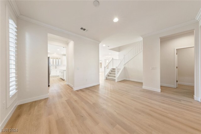 unfurnished living room with light hardwood / wood-style floors and ornamental molding