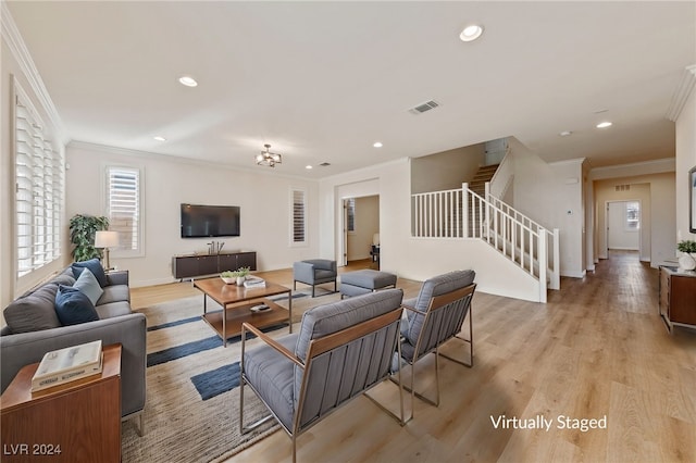 living room featuring light wood-type flooring, crown molding, and an inviting chandelier