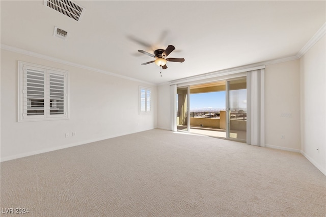 unfurnished room featuring light carpet, ceiling fan, and crown molding