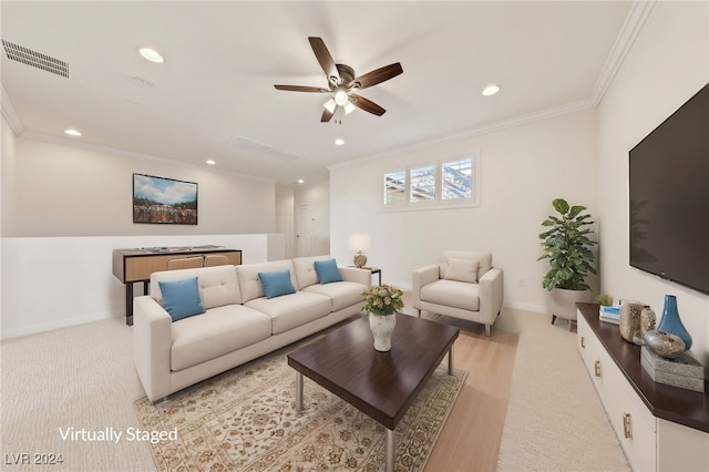 living room featuring ceiling fan, ornamental molding, and light hardwood / wood-style flooring