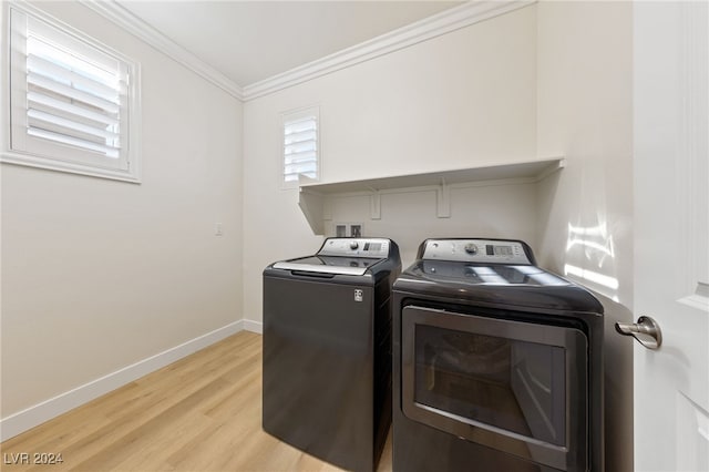 washroom featuring washer and dryer, light hardwood / wood-style flooring, and crown molding