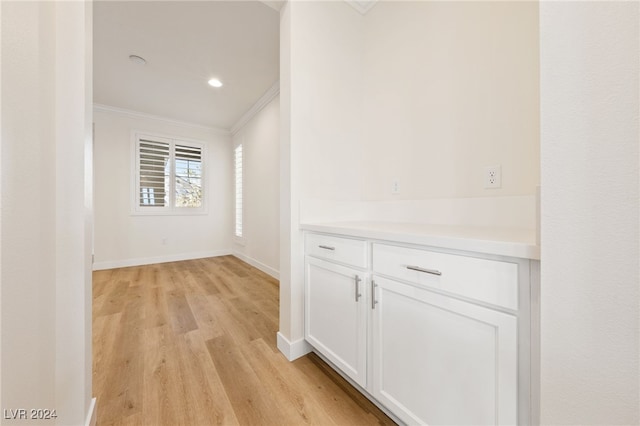 hall featuring ornamental molding and light hardwood / wood-style flooring