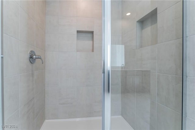 bathroom with a shower with door