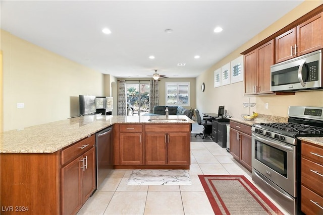 kitchen with ceiling fan, sink, stainless steel appliances, kitchen peninsula, and light tile patterned floors