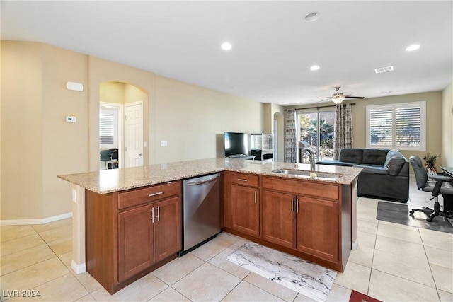 kitchen featuring stainless steel dishwasher, ceiling fan, sink, and an island with sink