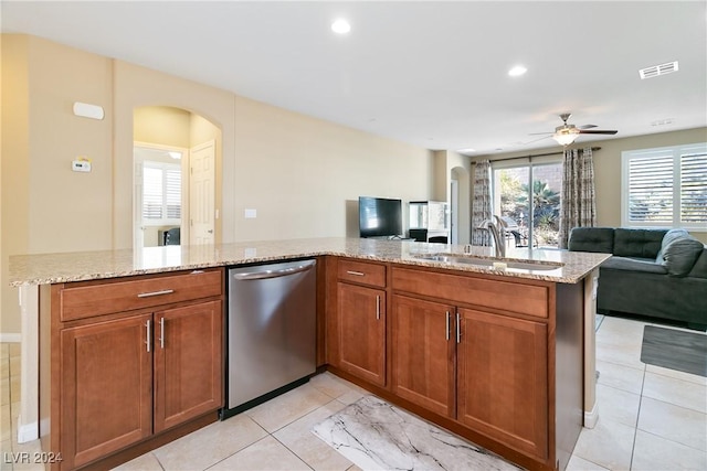 kitchen featuring dishwasher, light stone countertops, ceiling fan, and sink