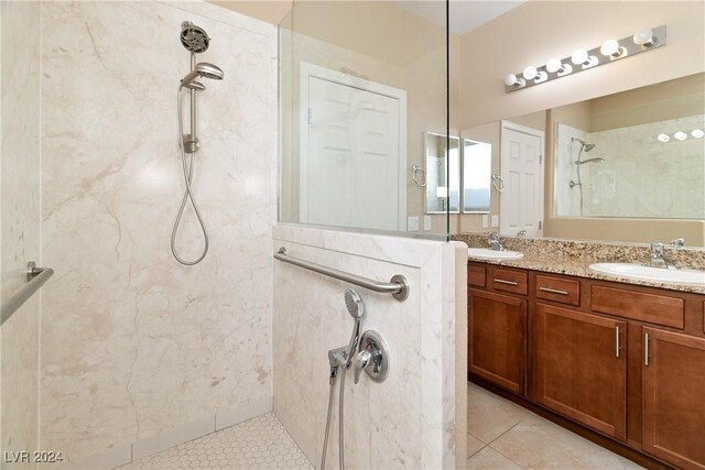 bathroom featuring tile patterned flooring, vanity, and tiled shower