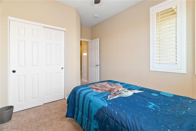 carpeted bedroom featuring ceiling fan and a closet