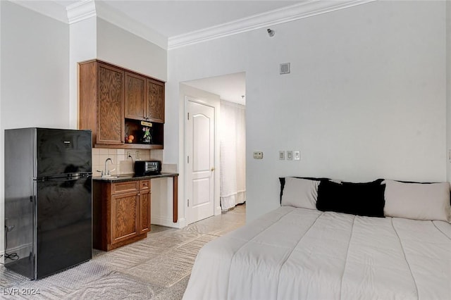 bedroom with black fridge, sink, and ornamental molding