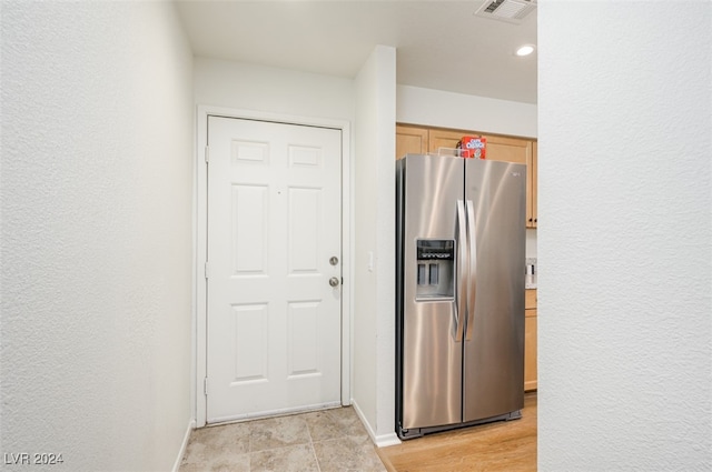 kitchen with light hardwood / wood-style floors, stainless steel fridge with ice dispenser, and light brown cabinetry