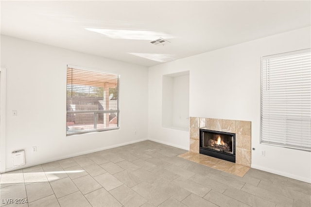 unfurnished living room featuring a fireplace and light tile patterned floors