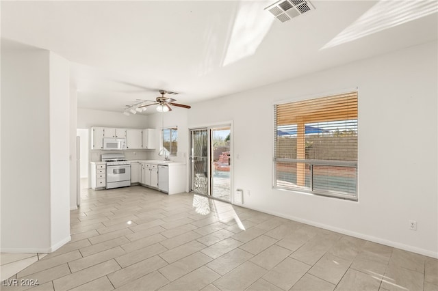 kitchen with white appliances, light tile patterned floors, ceiling fan, sink, and white cabinetry