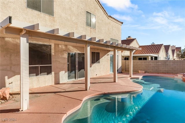 rear view of house featuring a patio and a fenced in pool