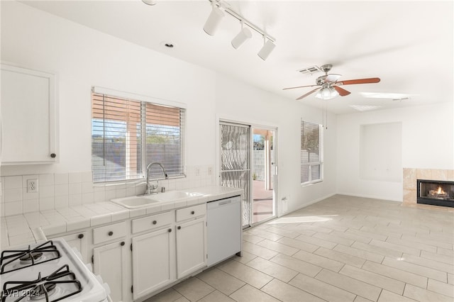 kitchen with sink, white cabinetry, white appliances, tile counters, and backsplash