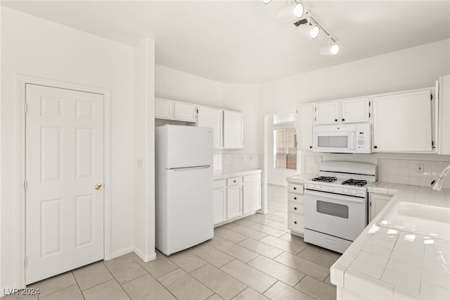 kitchen featuring white appliances, sink, and white cabinetry